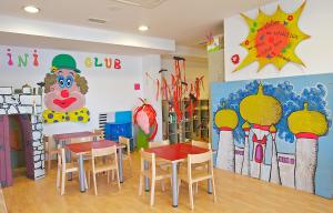 a classroom with tables and chairs and paintings on the walls at Arena Verudela Beach in Pula