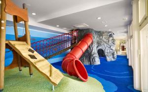 a childrens play room with a slide and a play equipment at Arena Verudela Beach in Pula