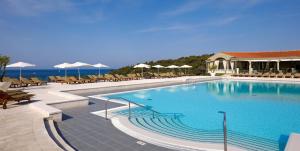 a large swimming pool with chairs and umbrellas at Arena Verudela Beach in Pula