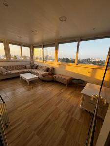 a large living room with a couch and windows at Sea View 1 Bedroom Apartment with 100m Terrace in Sousse