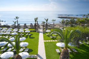 an view of a resort with white umbrellas and the ocean at Mediterranean Beach Hotel in Limassol