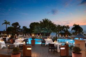 a restaurant with tables and chairs and a pool at Mediterranean Beach Hotel in Limassol +37 photos