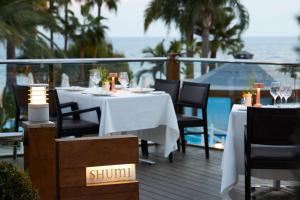 a restaurant with a table and chairs on a deck at Mediterranean Beach Hotel in Limassol