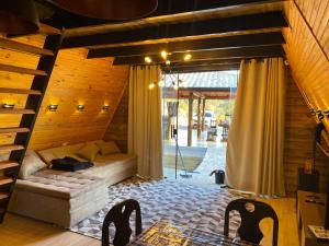 a living room with a bed in a wooden house at Chalé Bela Vista in Munhoz