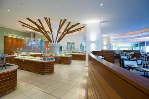 a restaurant with a dining area with tables and chairs at Mediterranean Beach Hotel in Limassol