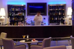 a woman standing behind a bar in a restaurant at Mediterranean Beach Hotel in Limassol