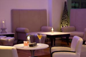 a living room with two tables and chairs and candles at Mediterranean Beach Hotel in Limassol