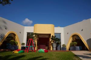 a house with a red ladder in the grass at Mediterranean Beach Hotel in Limassol