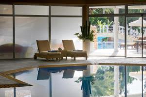 a living room with a pool and two chairs at Mediterranean Beach Hotel in Limassol