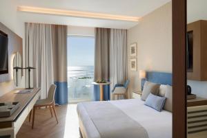a hotel room with a bed and a desk at Mediterranean Beach Hotel in Limassol