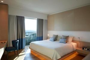 a hotel room with a bed and a large window at Mediterranean Beach Hotel in Limassol