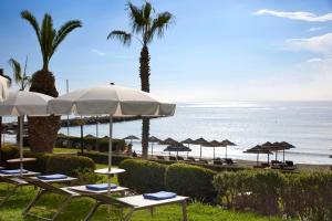 a beach with chairs and umbrellas and the ocean at Mediterranean Beach Hotel in Limassol