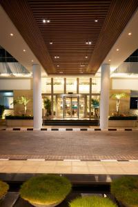 a lobby of a building with columns and grass at Mediterranean Beach Hotel in Limassol