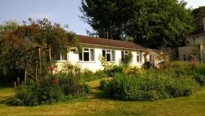 una casa bianca con un giardino di fronte di Robin Hill Cottage ad Amesbury