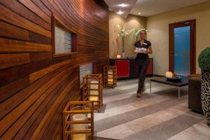 a woman walking through a room with wood paneling at Mediterranean Beach Hotel in Limassol