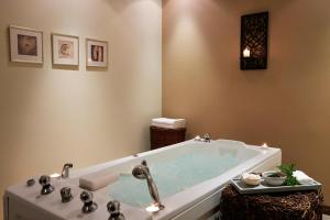 a bathroom with a bath tub with a sink at Mediterranean Beach Hotel in Limassol