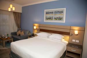 pokój hotelowy z dużym łóżkiem i krzesłem w obiekcie Swiss Inn Resort Hurghada w mieście Hurghada