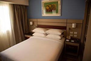 sypialnia z dużym łóżkiem i białymi poduszkami w obiekcie Swiss Inn Resort Hurghada w mieście Hurghada