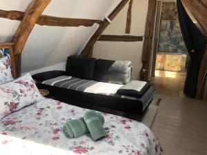 a living room with a couch and a bed at La Chapelle de Monet - Logis Jasmin in Bois-Jérôme-Saint-Ouen