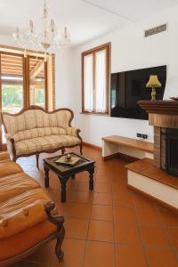 ein Wohnzimmer mit Couch und Kamin in der Unterkunft Villa Ferrara Royal Resort & Spa in Coriano