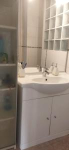 ein Badezimmer mit einem weißen Waschbecken und einem Spiegel in der Unterkunft Hébergement tout confort dans logement proche de la gare in Montpellier