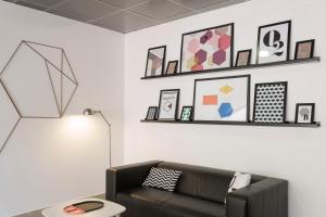 a living room with a couch and a shelf with pictures at B&B Hotel Firenze Nuovo Palazzo Di Giustizia in Florence