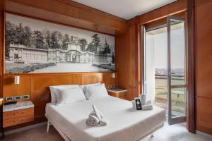 1 dormitorio con 1 cama y una foto de una casa en B&B Hotel Modena, en Módena