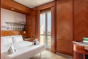 a bedroom with a bed and a large window at B&B Hotel Modena in Modena