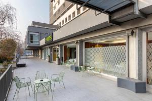 a patio with chairs and tables outside of a building at B&B Hotel Modena in Modena +37 photos
