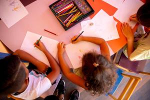 a group of children drawing on paper on a table at Sunny Days El Palacio Resort & Spa in Hurghada