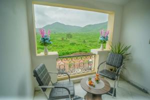 a balcony with a table and chairs and a window at Sunny Villa Entire With Pool in Udaipur