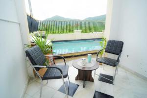 a patio with two chairs and a table and a pool at Sunny Villa Entire With Pool in Udaipur