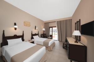 a hotel room with two beds and a television at Sunny Days El Palacio Resort & Spa in Hurghada