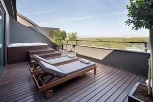 a balcony with a chaise lounger on a deck at Voyage Belek Golf & Spa Hotel in Belek