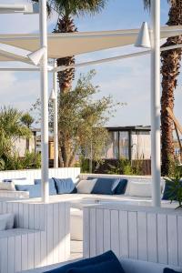 a white pergola with blue pillows on a patio at Voyage Belek Golf & Spa Hotel in Belek