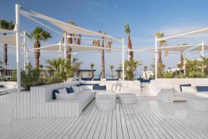 a white patio with white furniture and palm trees at Voyage Belek Golf & Spa Hotel in Belek +37 photos