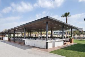 a pavilion with a bar in a park at Voyage Belek Golf & Spa Hotel in Belek