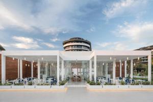 a building with tables and chairs in front of it at Voyage Belek Golf & Spa Hotel in Belek