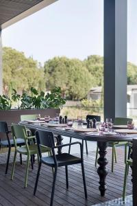 a table with chairs and wine glasses on a deck at Voyage Belek Golf & Spa Hotel in Belek