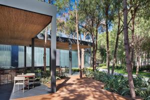 a pavilion with a table and chairs and trees at Voyage Belek Golf & Spa Hotel in Belek