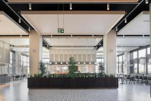 a lobby with tables and chairs and plants at Voyage Belek Golf & Spa Hotel in Belek