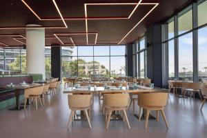 a restaurant with tables and chairs and large windows at Voyage Belek Golf & Spa Hotel in Belek