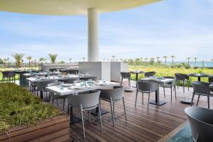 a restaurant with tables and chairs on a deck at Voyage Belek Golf & Spa Hotel in Belek