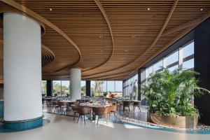 a dining room with tables and chairs and windows at Voyage Belek Golf & Spa Hotel in Belek