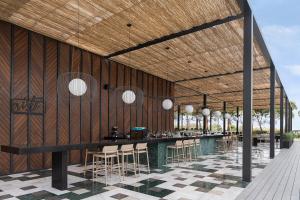 a restaurant with a bar with a wooden wall at Voyage Belek Golf & Spa Hotel in Belek