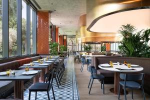 a restaurant with tables and chairs and windows at Voyage Belek Golf & Spa Hotel in Belek