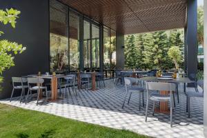 a restaurant with tables and chairs and windows at Voyage Belek Golf & Spa Hotel in Belek