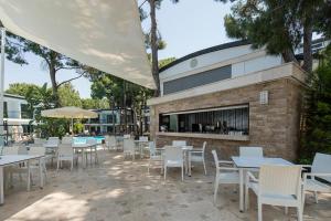 a patio with tables and chairs next to a building at Voyage Belek Golf & Spa Hotel in Belek