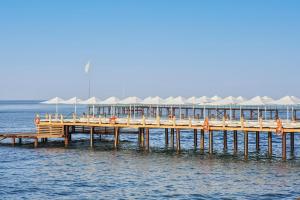 a wooden pier with umbrellas on the water at Voyage Sorgun Hotel in Side