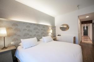 Cama ou camas em um quarto em Hotel Les Arcades